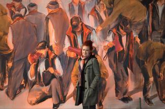 Lydia Thomas 2015 vor einem Gemälde ihrer Diplomarbeit: Communication Breakdown